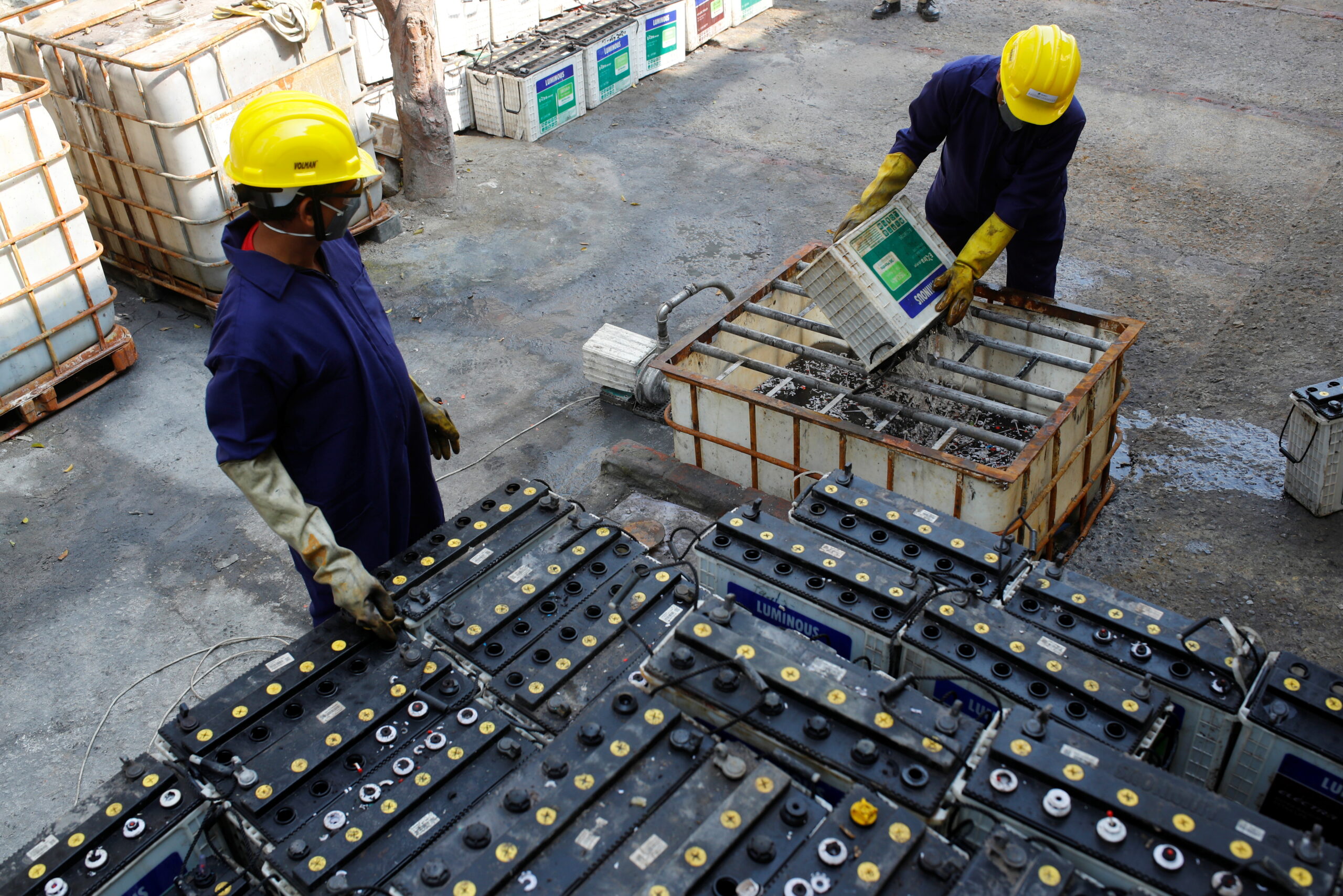 Workers dismantling waste batteries